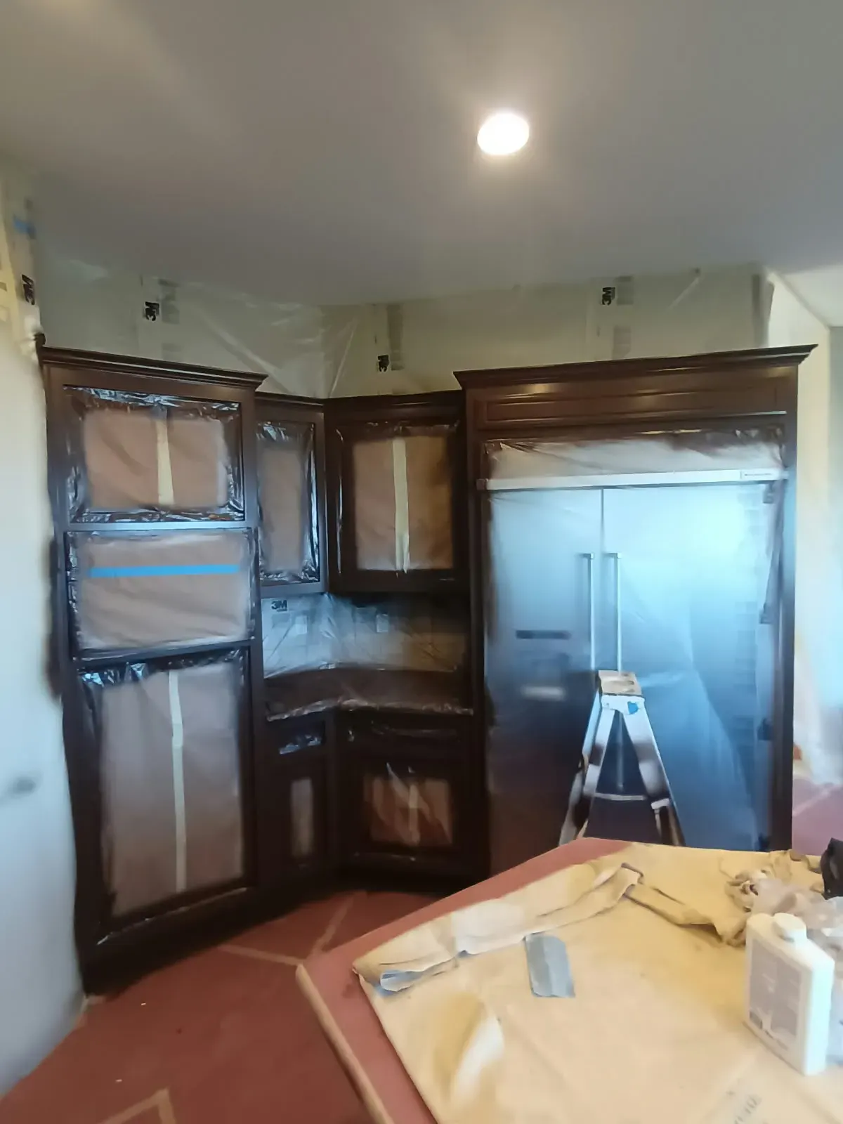 Cabinet refinishing in San Jose, CA: corner cabinets and refrigerator masked for finishing