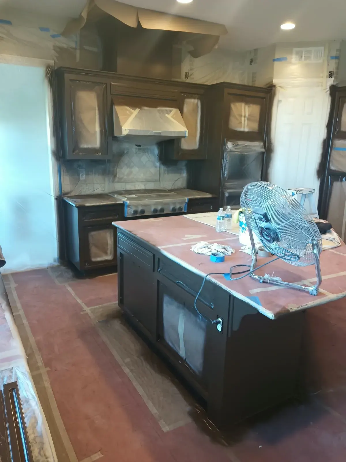 Cabinet painting in San Jose, CA: kitchen cabinets masked with paper and plastic for refinishing