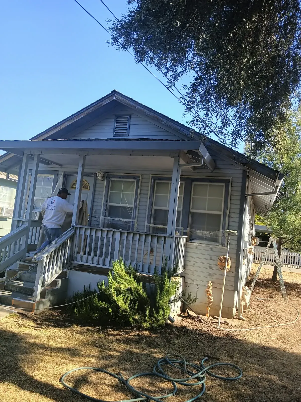 Painter working on a house exterior for De La Mora Painting in San Jose, CA