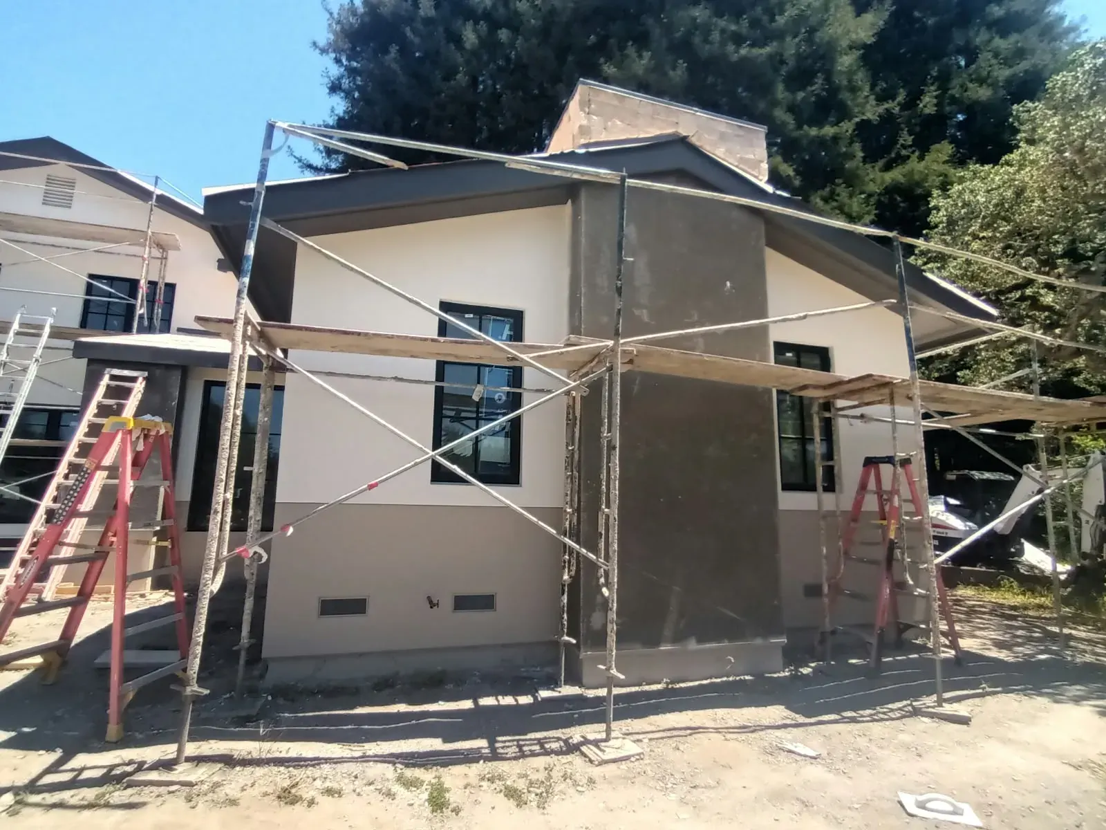Exterior painting in San Jose, CA: stucco house with scaffolding and ladders set up for painting