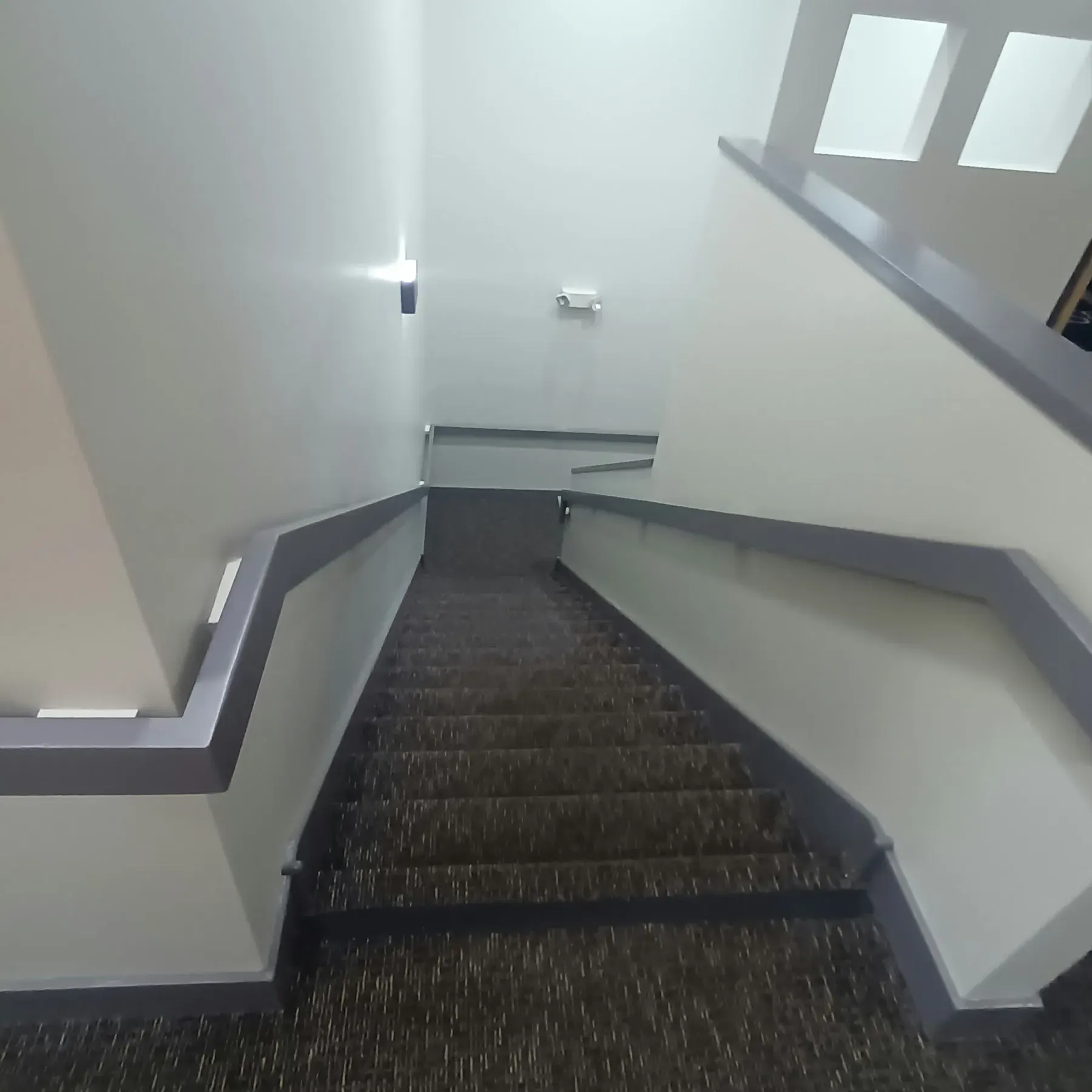 Staircase painting in San Jose, CA: commercial stairwell with painted gray rail and walls