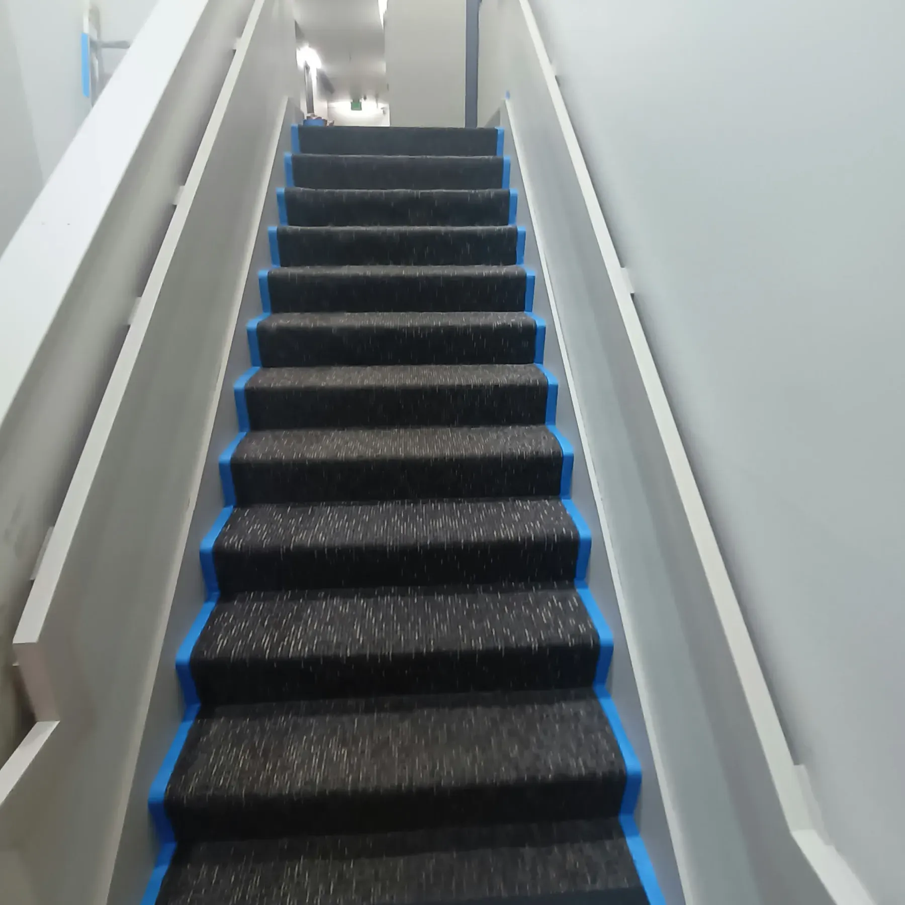 Staircase painting in San Jose, CA: carpeted stairs taped off with painted white rail