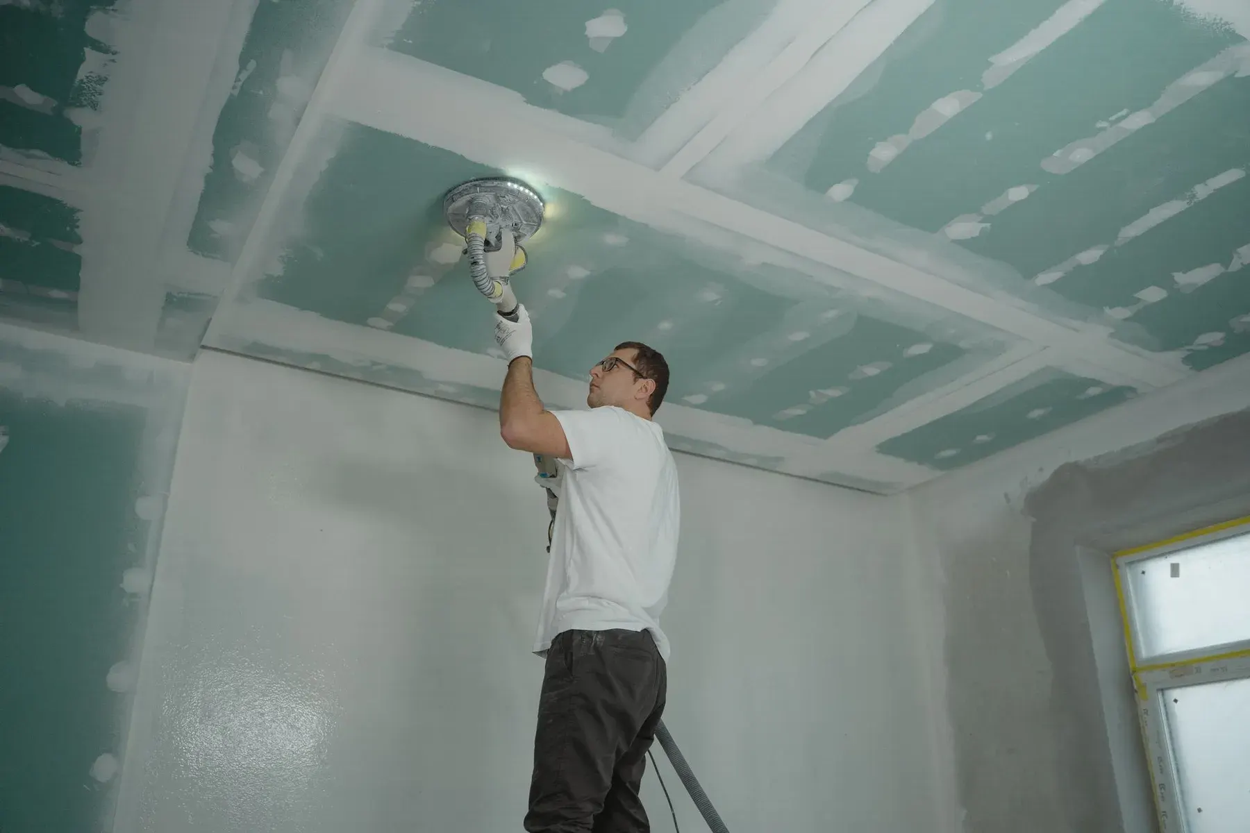 Ceiling finishing in San Jose, CA: sanding a ceiling smooth before texture