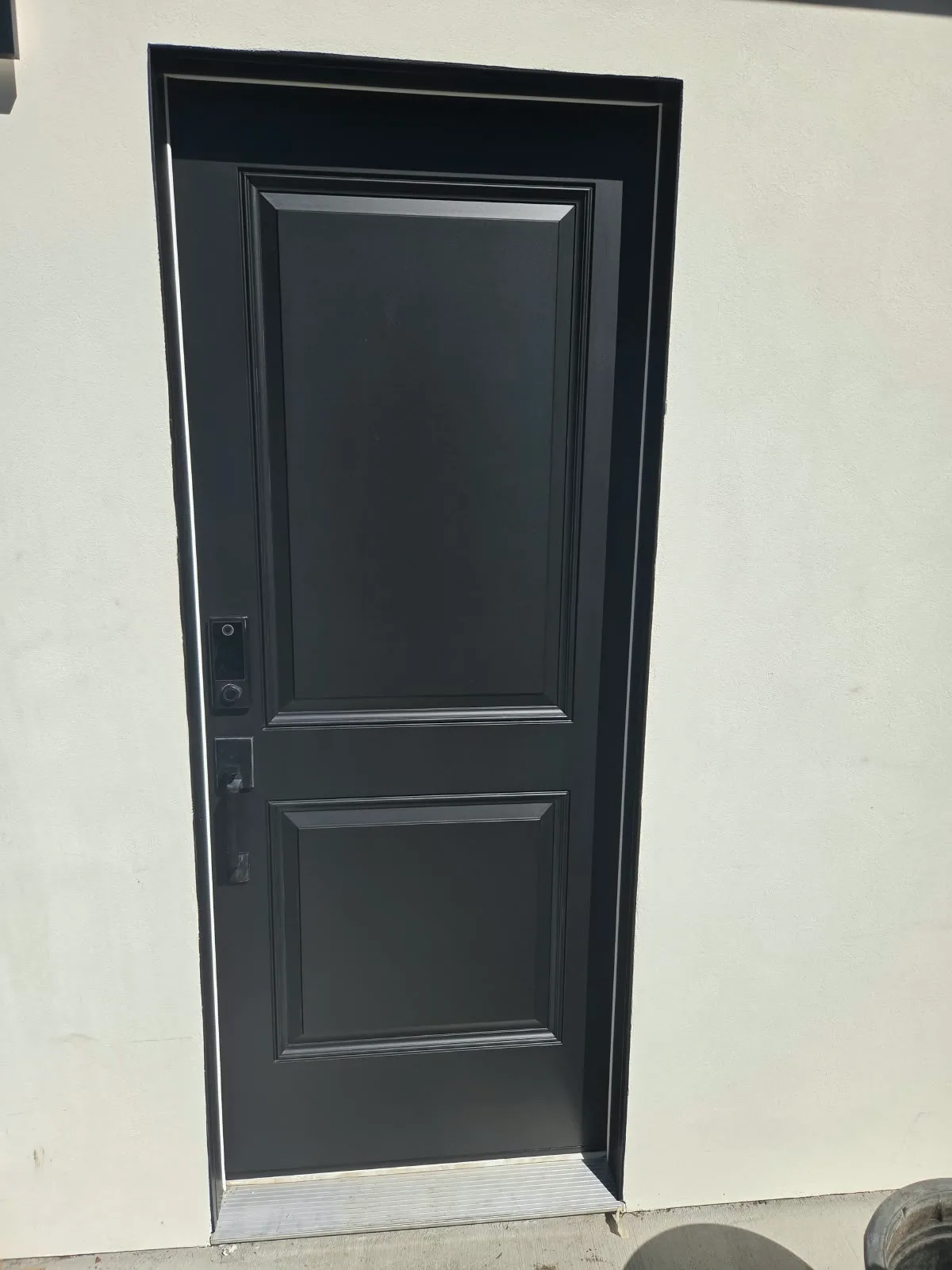 Door painting in San Jose, CA: black paneled entry door in cream stucco