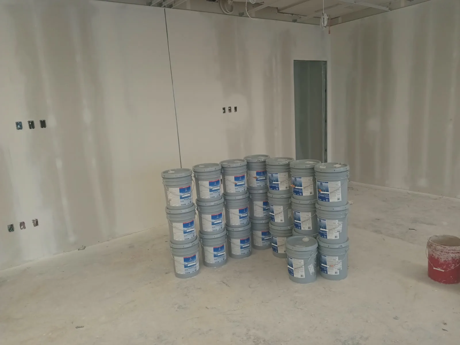 Drywall finishing in San Jose, CA: finished drywall walls with paint buckets staged