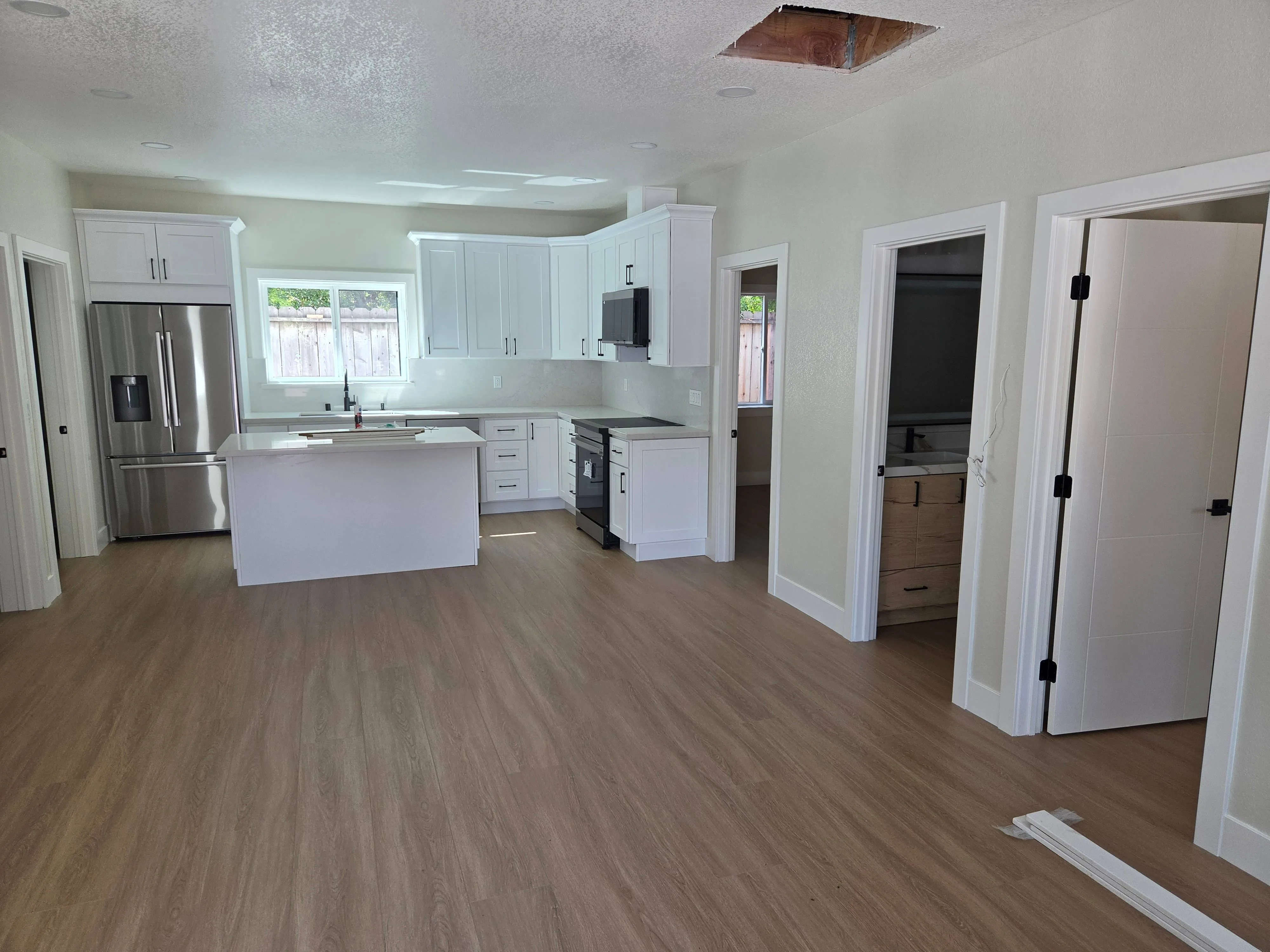 Interior painting in San Jose, CA: kitchen and hallway with white trim and doors