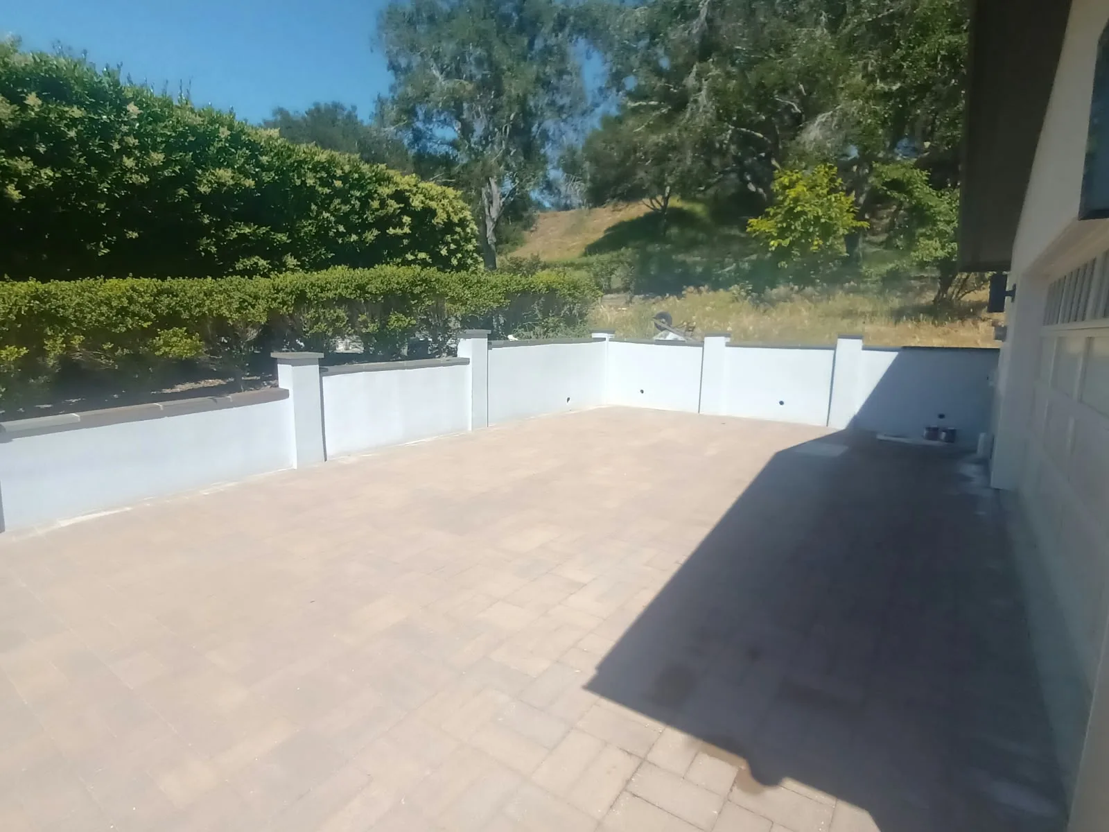 Exterior painting in San Jose, CA: freshly painted stucco wall around a paver patio