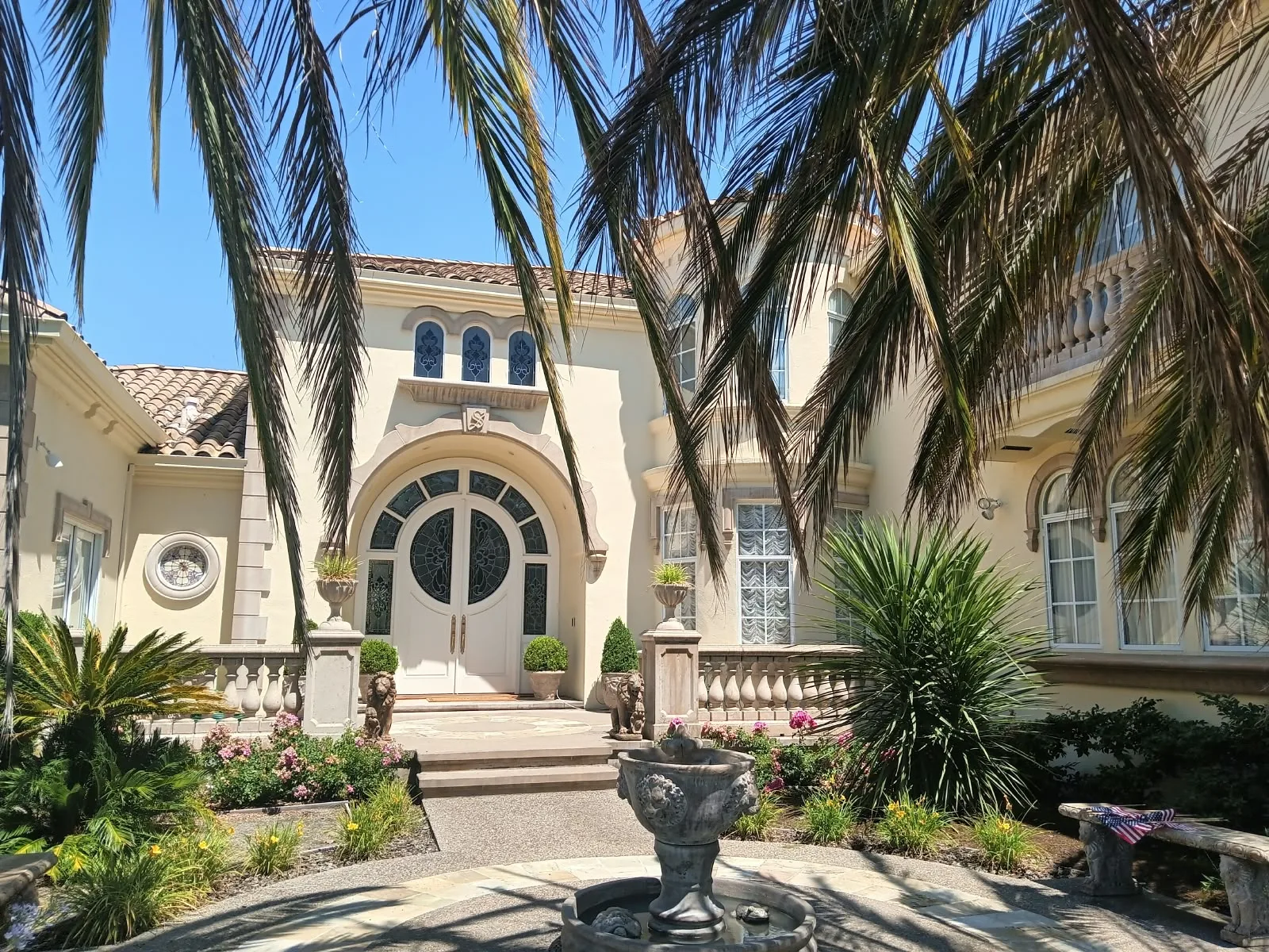 Exterior painting in San Jose, CA: stucco home with arched entry and palm trees